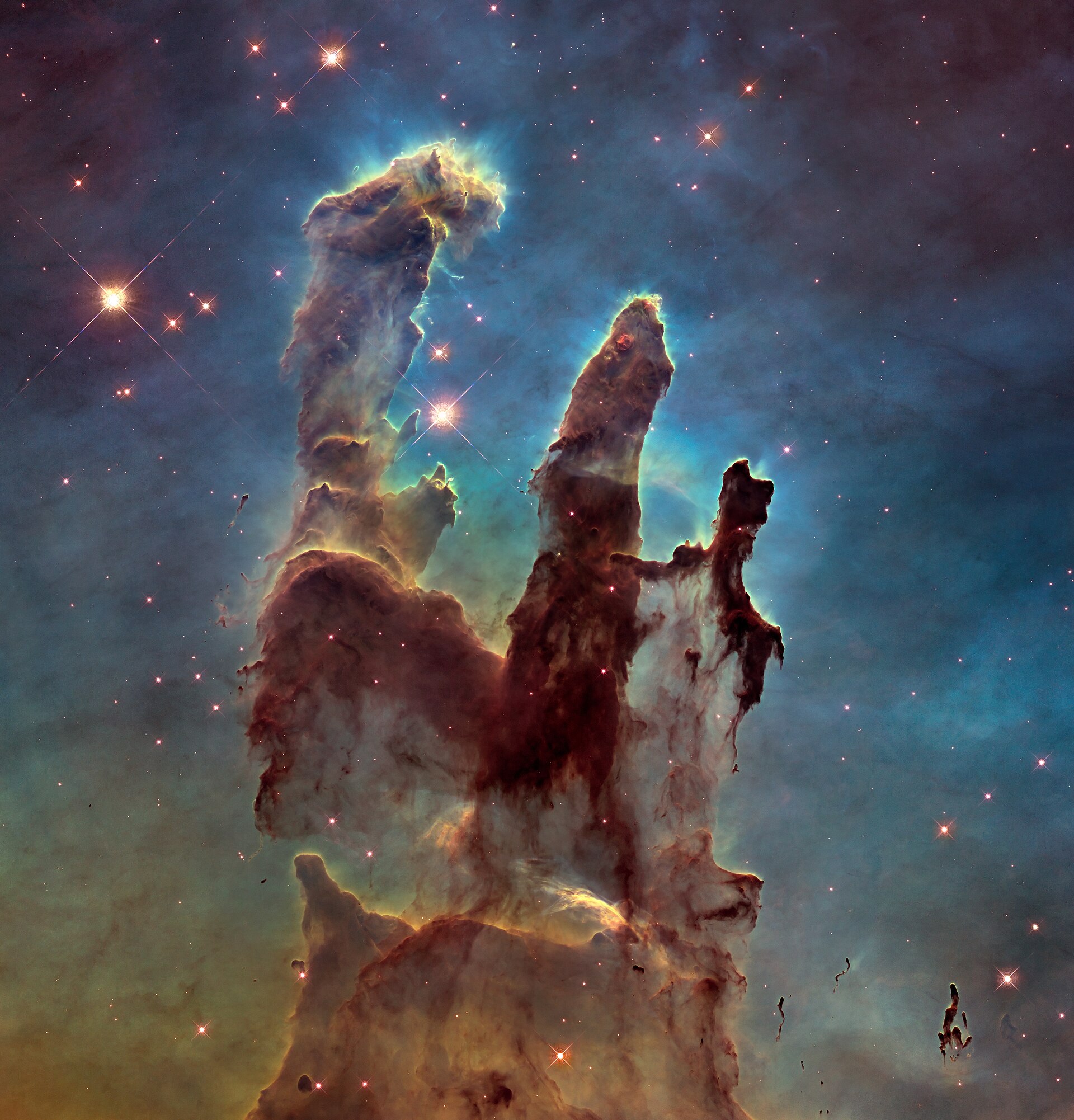 Towering columns of gas and dust glowing against a star-filled sky in the Eagle Nebula