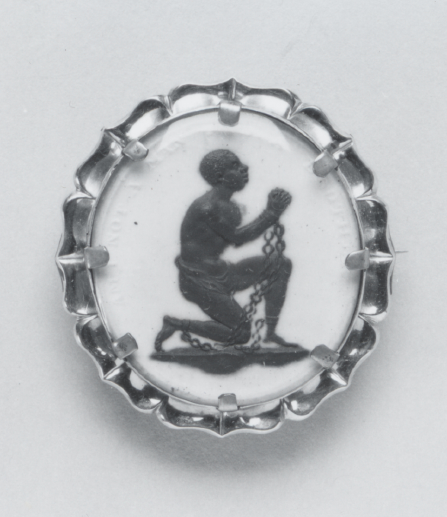 Philemon 2 A small white-and-black jasperware medallion showing a kneeling man in chains raising his hands, encircled by the words Am I not a man and a brother