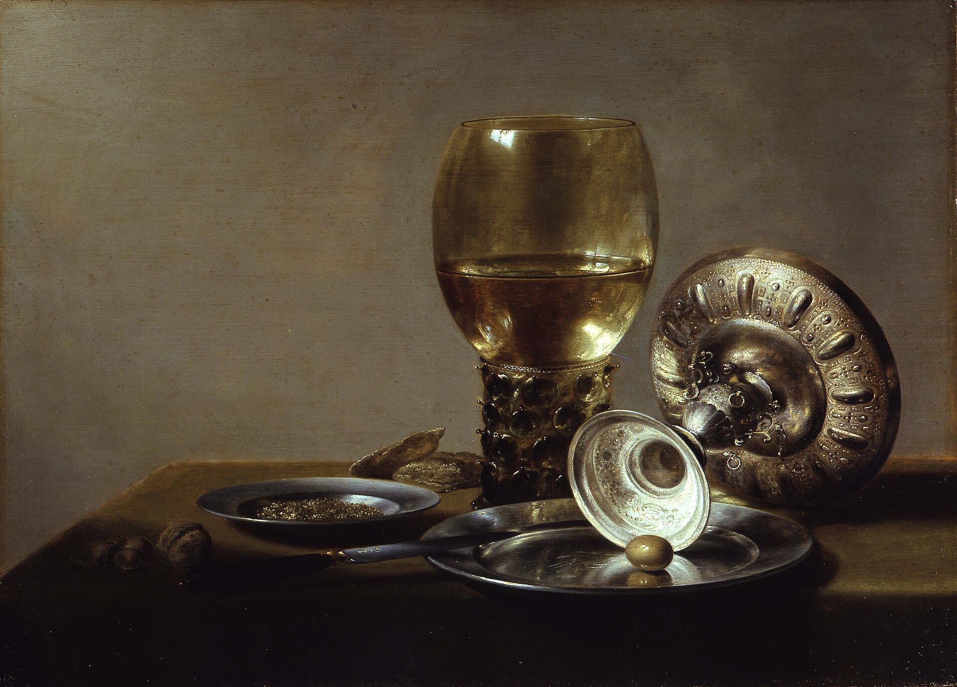 The Rechabites Who Would Not Drink 1 A tall green wine glass, a silver cup lying on its side, and a plate of food on a white tablecloth against a dark background
